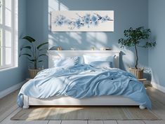 a bed with blue sheets and pillows in a room next to a potted plant