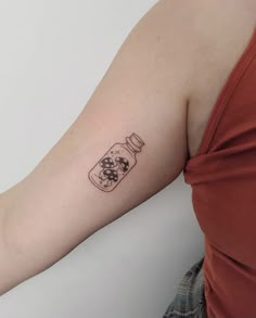 a woman with a tattoo on her arm holding a bottle in the shape of a dog