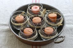 candles are placed in small glass containers on a table