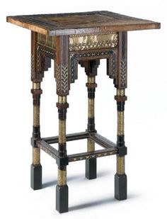 an ornately decorated wooden table with two small stools on each side and one foot in the middle