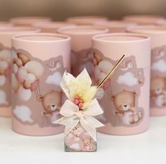 there are many pink mugs with teddy bears on them and one has a flower in it