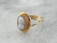 To complete this vintage ring, we've chosen an unusual, hefty cameo! This is a hard-stone cameo, a cameo carved not from shell, but from naturally banded agates, carnelians, or in this case, Sardonyx. The workmanship is detailed and lovely, and the simplicity of the gold setting allows the stone to be the centerpiece!Metal: 14K Yellow Gold Gem: Hardstone Cameo Gem Measurements: 13 x 9.5 mm Oval Ring Size: 9.25Marks: "14K A" Stamped on the inside bandSKU #: YPN3H7-NEach piece has been identified Classic Cameo Rings, Luxury Classic Cameo Ring, Vintage Gold Cameo Ring, Yellow Gold Cameo Ring Fine Jewelry, Cameo Ring Gem, Bike Jewelry, Mens Ring Designs, Cameo Ring, Cameo Jewelry