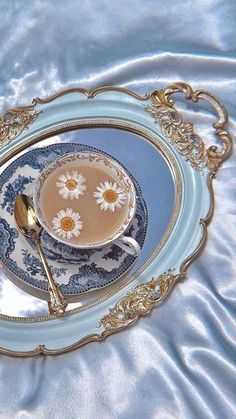 a tea cup and saucer on a blue plate with gold trimmings,