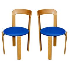 two wooden chairs sitting side by side with blue seats on each one and the other