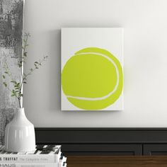 a green tennis ball on a white canvas mounted to a wall in a living room