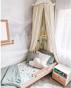 a bedroom with a canopy bed and white rugs on the floor, along with a window