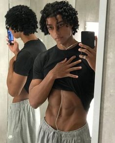 a man taking a selfie in front of a mirror with his cell phone and earphones