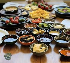 a table topped with bowls filled with different types of food and dipping sauces on top of it