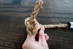 a person holding a rope on top of a wooden table