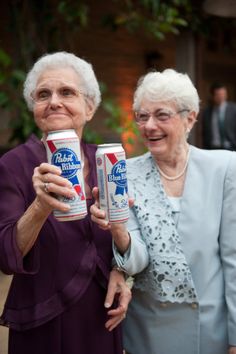 two older women holding cans of beer in their hands