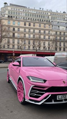 a pink lamb suv parked in front of a building