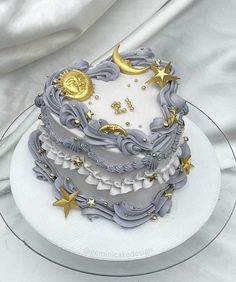 a white and gold decorated cake sitting on top of a glass plate