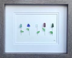 three different colored flowers in a white frame