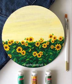 a painting with sunflowers painted on it next to paintbrushes and paints