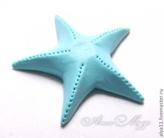 a blue starfish is sitting on a white surface