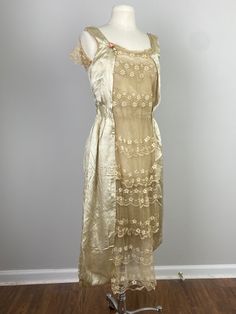 a dress on a mannequin stand in front of a gray wall and wooden floor