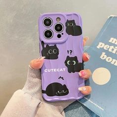 a person holding a purple phone case with black cats on it and the words cute cat