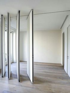 an empty room with white walls and wood flooring is seen in this image from the inside