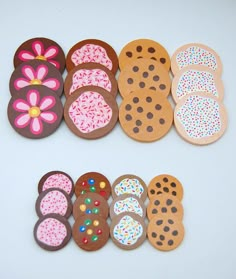 several decorated cookies are laid out on a white surface with sprinkles and polka dots