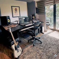 a room with a keyboard, guitar and other musical equipment on the floor in front of a window