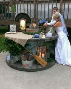 a bride and groom standing in front of an outdoor table