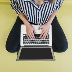 a woman sitting on the floor with her laptop in front of her feet and hands