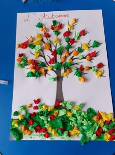 a tree made out of tissue paper on top of a blue table