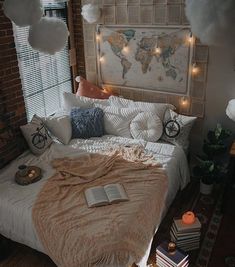 a bed with pillows and blankets on top of it in a bedroom next to a brick wall