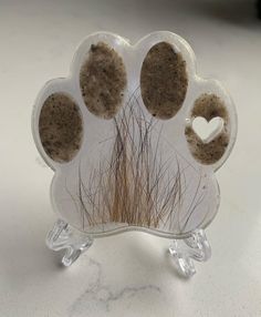 an animal's paw with three holes in the middle and two hearts on it