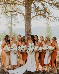 a group of women standing next to each other in front of a tree