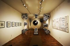 an art gallery with multiple pieces of artwork on the wall and wooden flooring in front of it