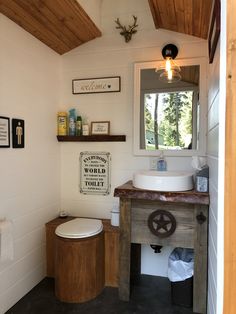 a bathroom with a sink, mirror and toilet in it's corner area next to a window