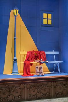 a blue and yellow building with a bench and lamp post in front of the window