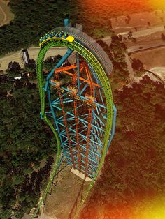 an aerial view of a roller coaster in the middle of a wooded area with trees