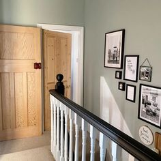 there are pictures on the wall above the bannister and below the stairs in this house