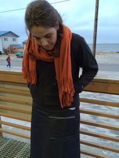 a woman wearing an orange scarf and black apron