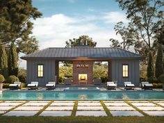 an outdoor pool with lounge chairs and a fire place next to it, surrounded by trees