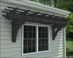 an outside view of a house with a window and awning on the side of it