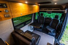 the interior of an rv with leather seats and wood paneling on the walls,