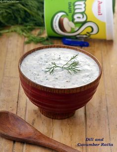 a wooden bowl filled with white sauce next to a bag of yogurt