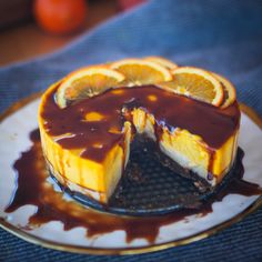 a cheesecake with chocolate sauce and orange slices