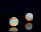 three small round objects sitting on top of a black surface with reflective light around them