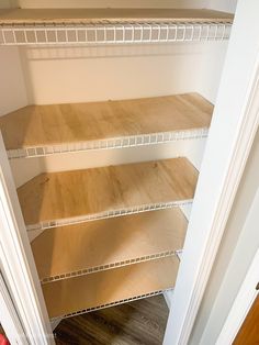 an empty closet with shelves and wood flooring