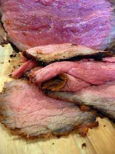 sliced meat sitting on top of a wooden cutting board