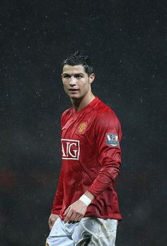 a soccer player in the rain holding an umbrella