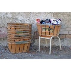 two wooden baskets sitting next to each other on top of a white metal chair near a brick wall