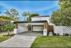 a house with a driveway and trees in the background