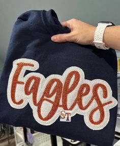 a person holding onto a bag with the word eagles on it