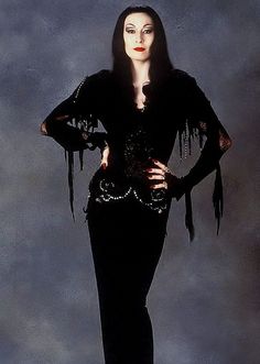 an image of a woman dressed in black with fringes on her arms and legs