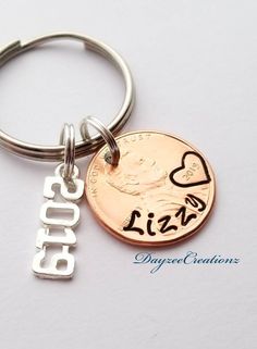 a close up of a key chain with a coin on it and the word love written in cursive writing